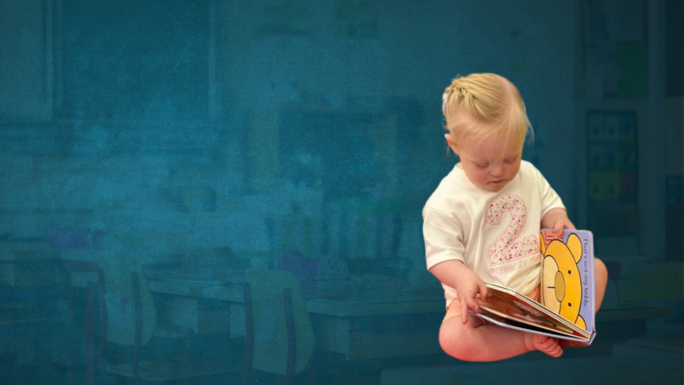 Young child with down syndrome opens up a book