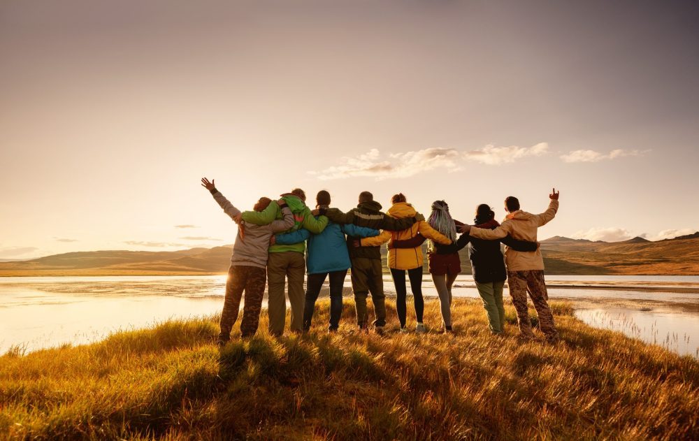People holding each other and looking out in the mountains for the three peaks challenge