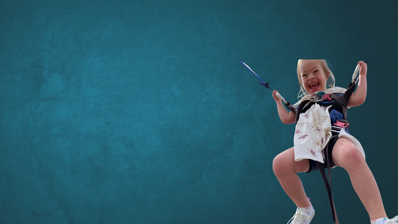 Child in harness on one of those trampoline rides at the fair ground. The background has been removed and replaced with a generic blue washout