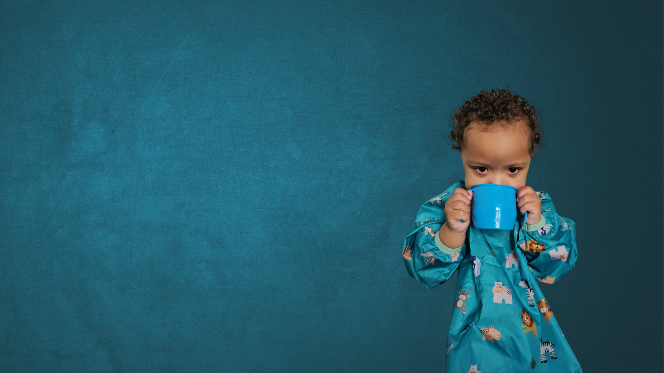 Young child holding a sippy cup with two hands