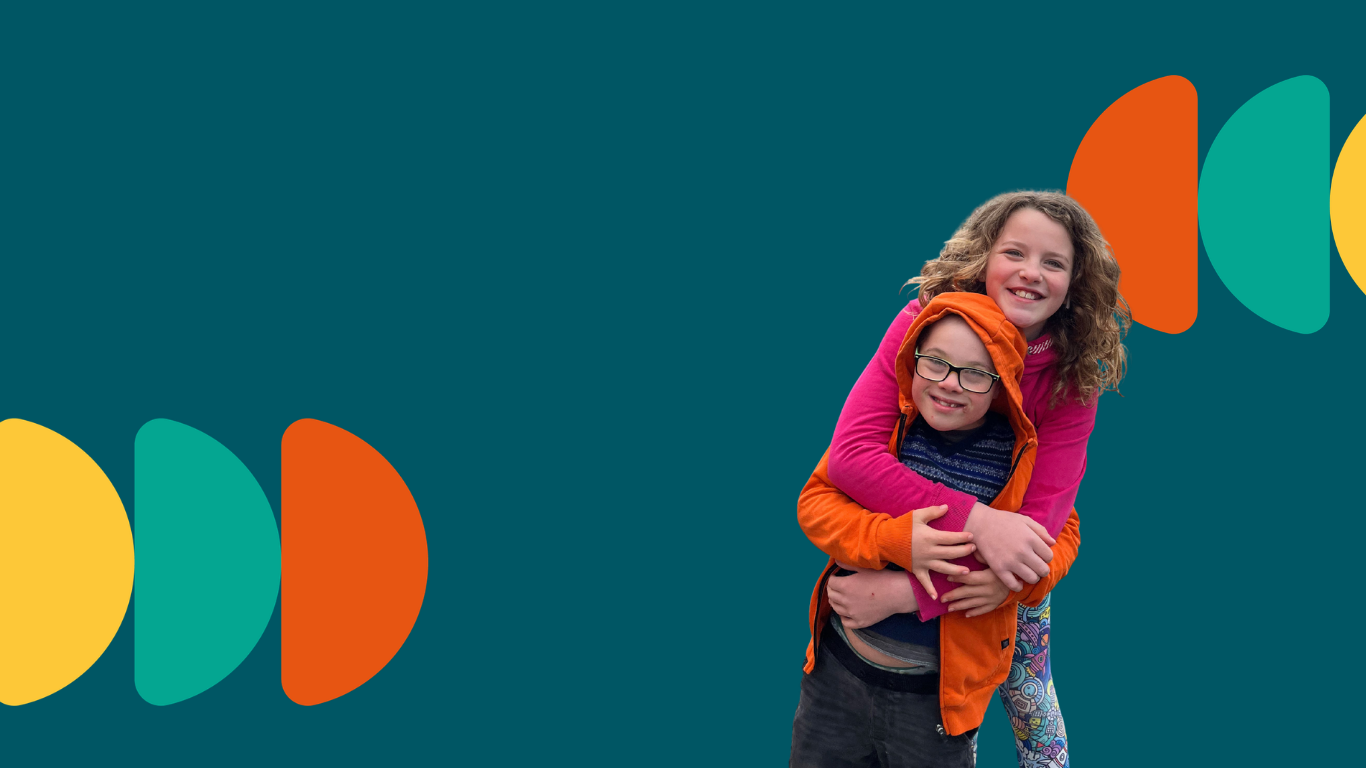 Young boy with down syndrome gives his sister a piggy back