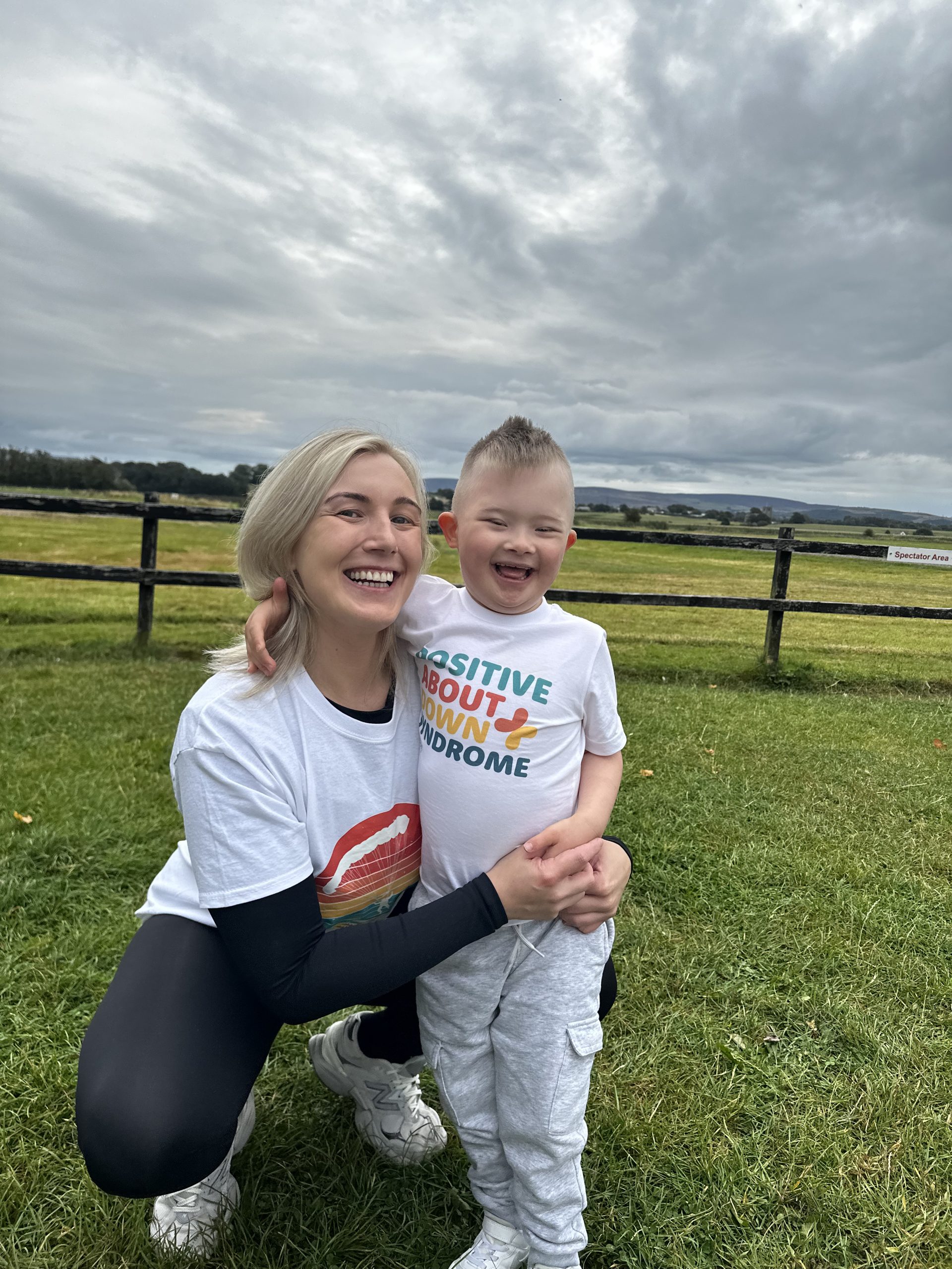 Jacqueline McGurk holding her son wearing a Positive About Down Syndrome shirt